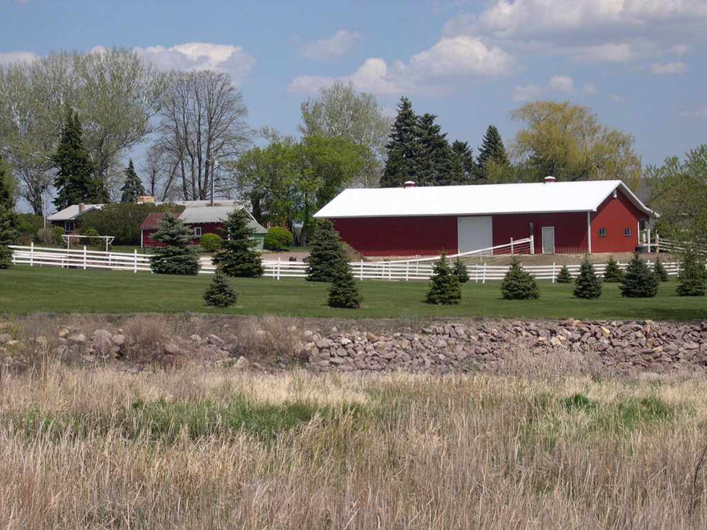 A large, red pole barn in a homestead